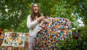 Stacey Putnam shows one of her quilts.