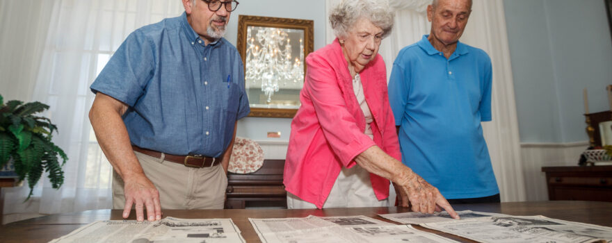 From left, Brian Beck, Mary McWilliams, and Gene Cleveland look over historic photographs inside the Winston home in Tuscumbia.