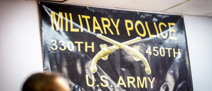A banner honoring the 330th and 450th Military Police units of the U.S. Army hangs on display during a meeting on Monday, April 28, 2025, in Sheffield, Ala.
