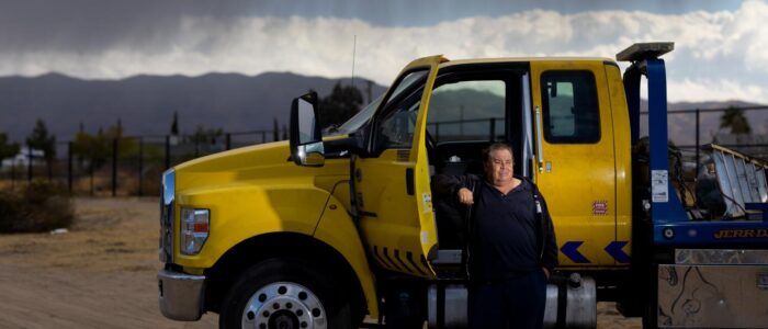 A year after the 10 Freeway fire, Alfredo Lara is struggling to get his business back up and running in Hesperia Friday, Nov. 15, 2024. Alfredo Lara stands in his new tow yard with a flat bed tow truck he purchased four months ago after his towing business under the 10 Freeway was destroyed where he lost several vehicles and two forklifts for an estimated loss of $150,000. A year ago an early morning fire exploded below an overpass of the 10 Freeway in downtown Los Angeles, severely damaging the structure and leading officials to close about two miles of the heavily trafficked route for days. The fire destroyed several businesses operating underneath the freeway, many of the merchants were immigrants. Among those impacted by the fire that year was Alfredo Lara.