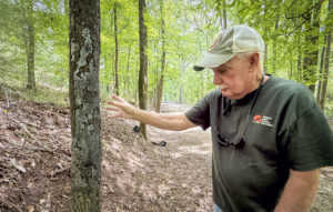 Steve McEachron explains a condition that causes trees to produce living tissue damaging their own bark under certain environmental stress, while walking a trail at Wildwood Park on Wednesday, April 30, 2025, in Florence, Ala.