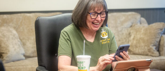 Pam Belew reacts while looking at her phone during a Florence Pilot Club.