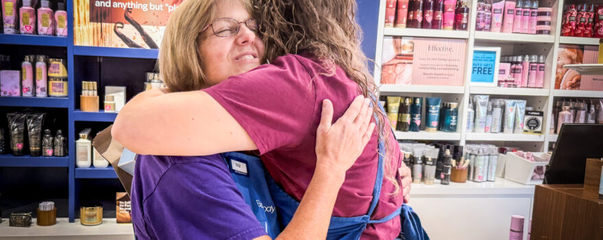Gloria “Gigi” Broadway hugs a co-worker at Bath & Body Works in Florence.