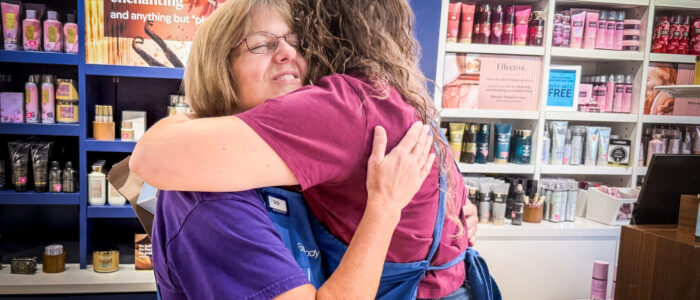 Gloria “Gigi” Broadway hugs a co-worker at Bath & Body Works in Florence.