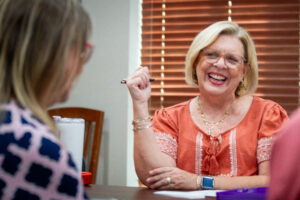 Nancy Ann Sherman, center, laugh