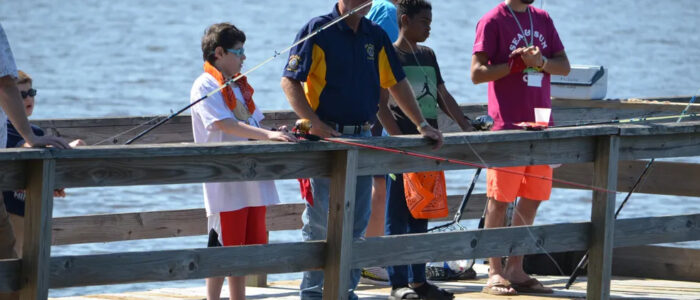 Campers at the Sea & Sun Camp fish from a pier.