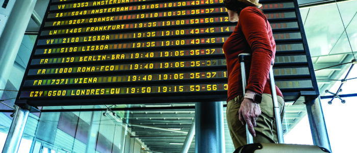 A woman looks at digital arrival and departure board.