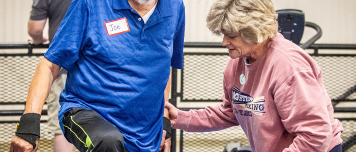 Sara Huntley, right, assists a participant with a leg-strength exercise