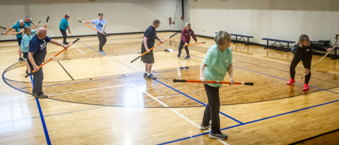 Participants practice balance and coordination drills using resistance sticks