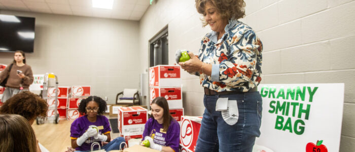 Jeanine Martin works with student volunteers to polish apples during a Junior League of the Shoals’ meeting inside the Handy Recreation Center in Florence. [DAN BUSEY/TIMESDAILY]