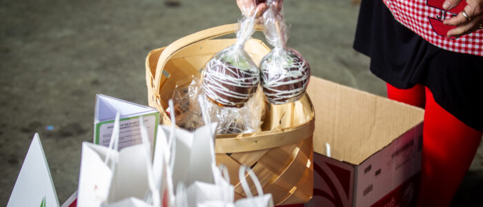 Jeanine Martin stocks gourmet chocolate-covered apples while preparing gift baskets for the Junior League of the Shoals’ Apple Annie Day fundraiser outside Sam’s Club in Florence. [DAN BUSEY/TIMESDAILY]