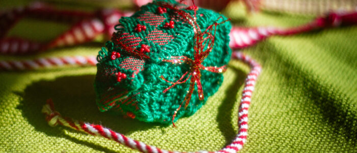 A small green and red woven ornament