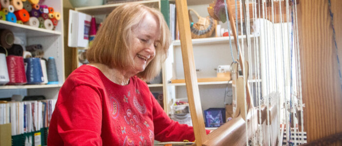 Sheffield weaver Kate Chitwood laughs as she works at her loom