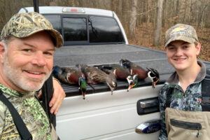 Lane Austin, left, and his son, Brayden, pose with harvested ducks following a hunt.