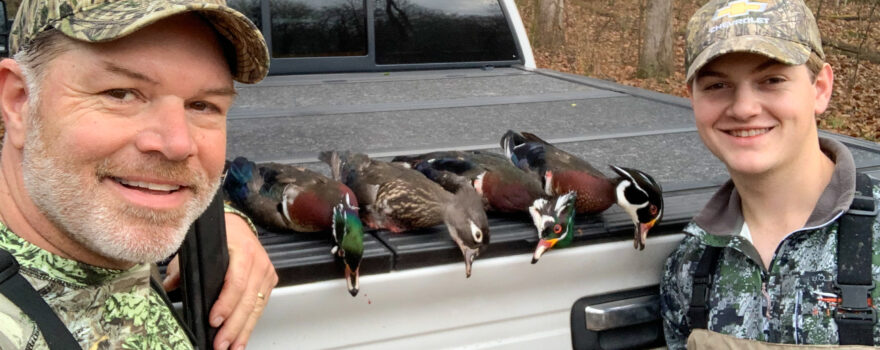 Lane Austin, left, and his son, Brayden, pose with harvested ducks following a hunt.