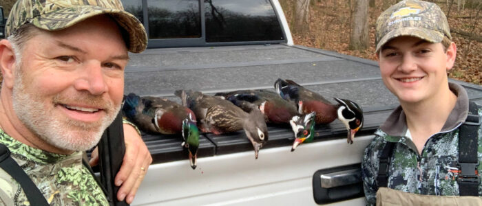 Lane Austin, left, and his son, Brayden, pose with harvested ducks following a hunt.